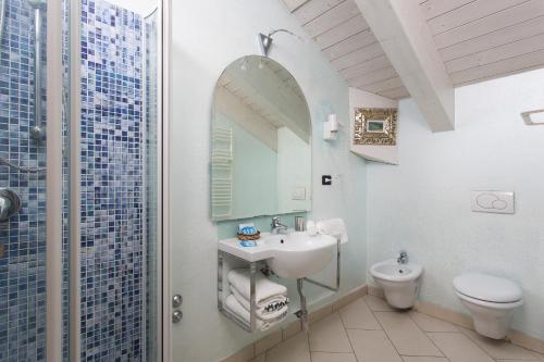 a bathroom with a sink and a toilet at Hotel Flora in Milano Marittima