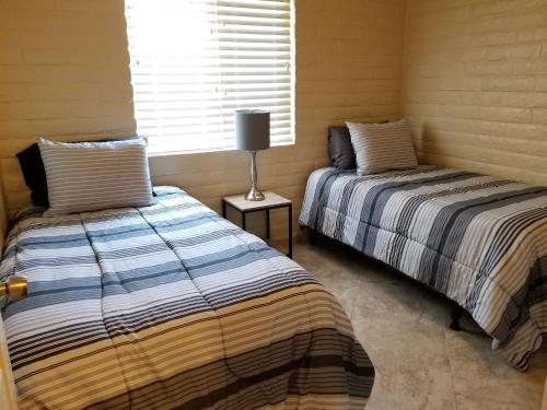 two beds sitting next to each other in a room at Tucson Airport Oasis in Tucson