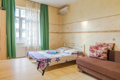 een kleine kamer met een bed en een bank bij Квартира по улице Коновальца, 36-Э in Kiev