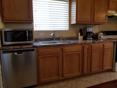eine Küche mit einer Spüle und einer Mikrowelle in der Unterkunft Tucson Airport Oasis in Tucson