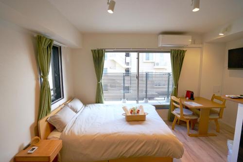 Jeffery Skytree Residence Tokyo في طوكيو: غرفة نوم بسرير ومكتب ونافذة