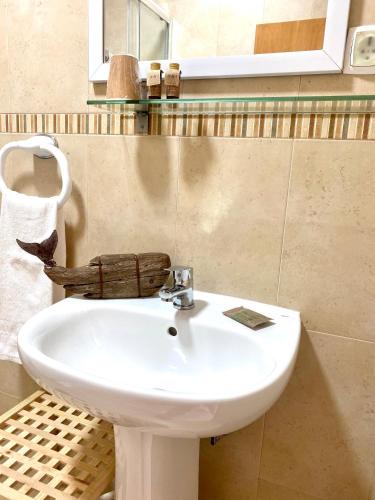 a bathroom with a white sink and a mirror at Pátio Abílio Guest House in Nazaré
