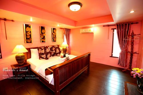 a bedroom with a bed and a window at Love Bridge House บ้านสะพานรัก in Sangkhla Buri