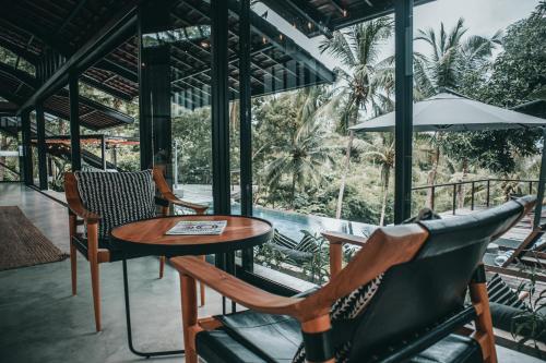 a restaurant with a table and chairs and a view of a pool at Villa Kiri, Secluded Jungle Paradise in Selong Belanak