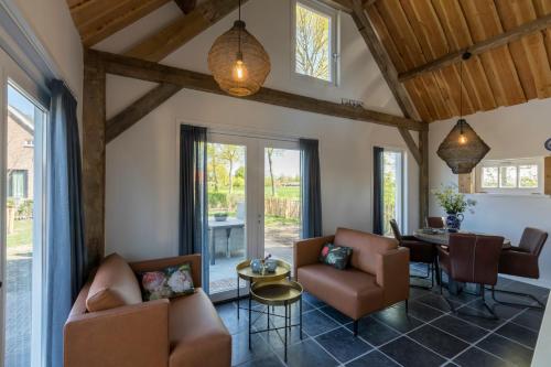 a living room with couches and a table at Welcome in - Vakantiewoning met grote tuin en green egg I Lepelstraat 18c Vrouwenpolder in Vrouwenpolder