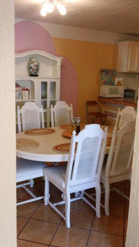 a dining room with a table and white chairs at Welcome To Casa OLE Playas de Tijuana 5-Rooms 14-Guests close to Shoping Center & Beach in Tijuana
