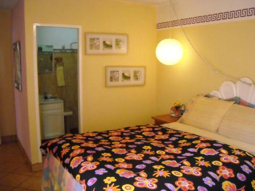 a bedroom with a bed with a flowered blanket at Welcome To Casa OLE Playas de Tijuana 5-Rooms 14-Guests close to Shoping Center & Beach in Tijuana