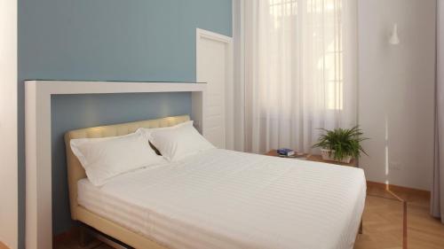 a bedroom with a large bed with white sheets at Hotel Le Nuvole Residenza d'Epoca in Genoa