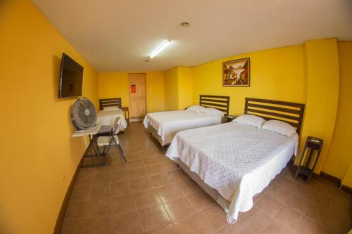 a hotel room with two beds and a fan at Euro Hostal in Guatemala