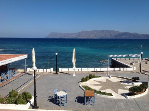 a view of the ocean with tables and chairs at Argo Rooms-Papadakis in Kissamos