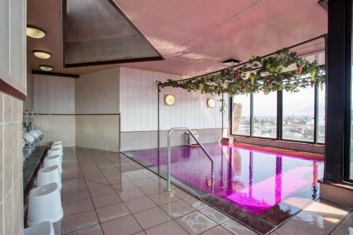 baño con una piscina con ventanas en Hotel Hatta, en Fuefuki
