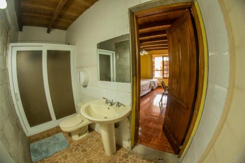 a bathroom with a sink and a toilet and a mirror at Euro Hostal in Guatemala