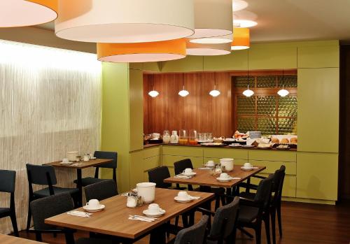 a restaurant with wooden tables and chairs and a counter at Hotel Henry in Dreieich