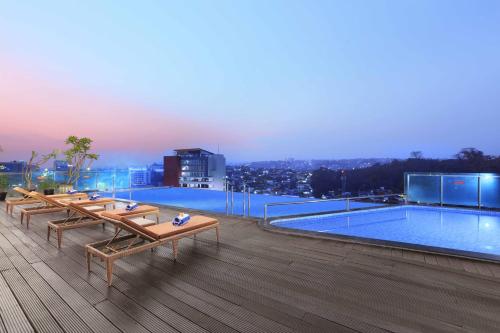a pool on the roof of a building with benches at ASTON Inn Pandanaran in Semarang