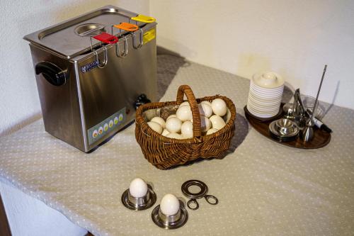 a basket of eggs on a counter next to a toaster at Hotel Silvapina in Klosters