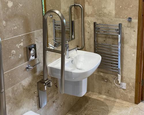 ein Badezimmer mit einem weißen Waschbecken und einem Spiegel in der Unterkunft The Carpenters Arms in Thirsk