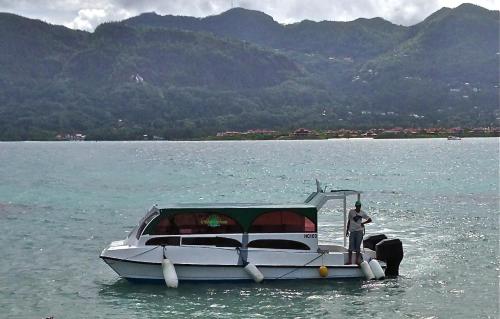 a man standing on a boat in the water at L'Habitation Cerf Island in Cerf Island
