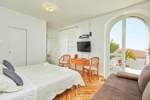 une chambre avec un lit, une table et une télévision dans l'établissement Villa Kate Dadić, à Dubrovnik