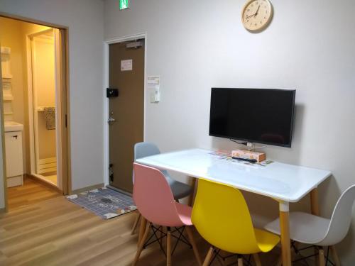 a room with a table with chairs and a computer monitor at Issyuku Higashiueno Hotel in Tokyo