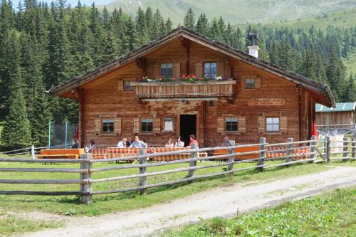 a group of people standing in front of a log cabin at Ganzenhubhof in Goldegg