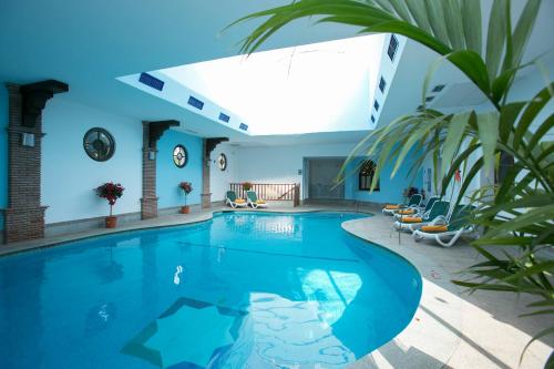 a swimming pool in a house with a blue ceiling at Ona Alanda Club Marbella in Marbella