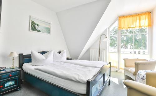 1 dormitorio con 1 cama, 1 silla y 1 ventana en Hotel Gastmahl des Meeres en Sassnitz