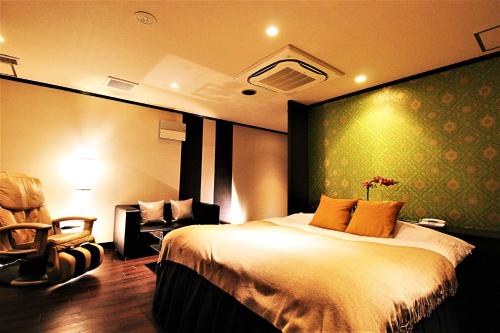 a hotel room with a bed and a chair at HOTEL O2 -Adult Only- in Hirabari