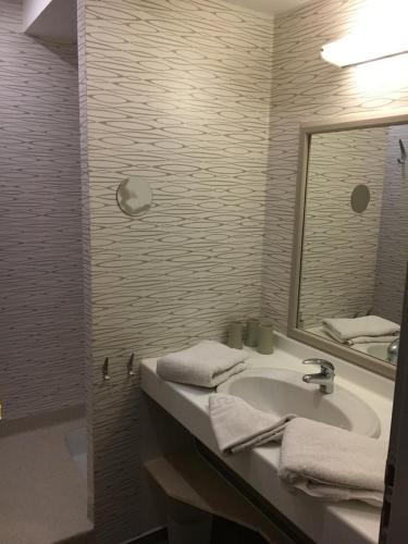 a bathroom with a sink and a mirror and a tub at La Demeure des 2 Trésors in La Bresse