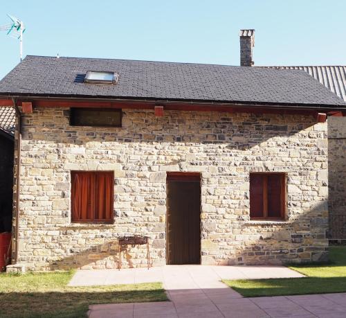 una casa de ladrillo con dos puertas y un techo negro en Casas rurales en Fanlo y Valle Vio, en Fanlo del Valle de Vío