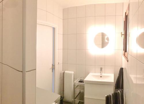 une salle de bain blanche avec un lavabo et un miroir dans l'établissement Super Bestouan, à Cassis
