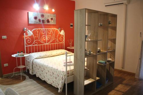 シラクーサにあるLa Piccola Casa di Angelaの赤い壁のベッドルーム1室(ベッド1台付)