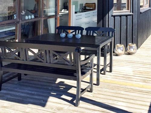 a black table and chairs on a porch at 8 person holiday home in Hj rring in Hjørring