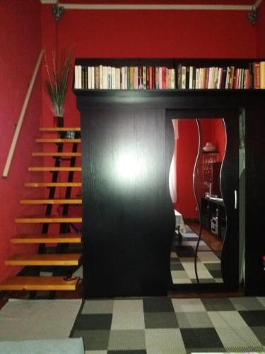 a living room with a book shelf and stairs at Studio Gizella in Budapest
