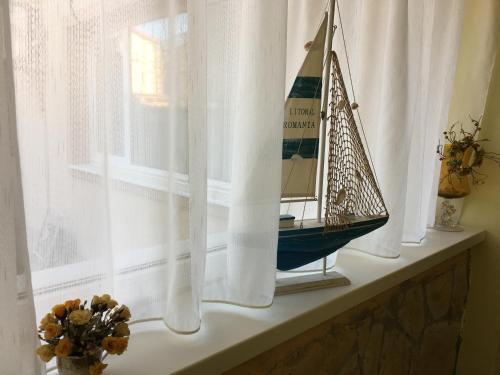 a window sill with a toy sailboat on it at Vila Casa Esy in Eforie Nord