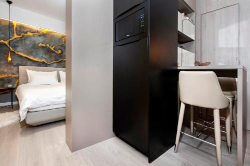 a small kitchen with a desk and a chair next to a bed at Deluxe Studio G 12 in Rovinj