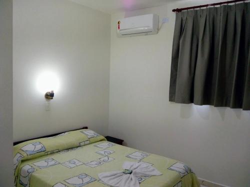 um pequeno quarto com uma cama e uma janela em Colina Park Hotel em Piracicaba