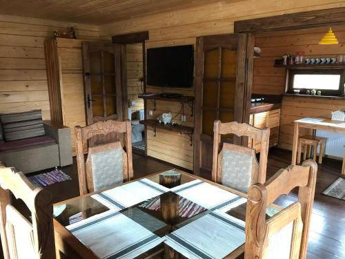 a wooden dining room with a table and chairs at Kozichky Guest House in Tatariv