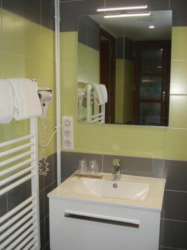 a bathroom with a sink and a mirror at Auberge Aux Portes de Conques in Saint-Cyprien-sur-Dourdou