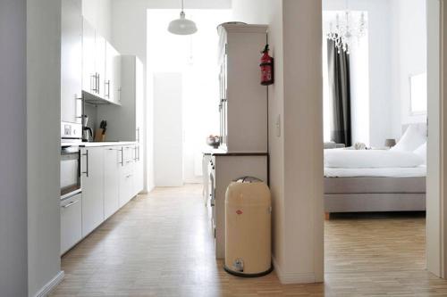 a white kitchen with a suitcase in the middle of a room at SC 6 Cozy Family & Business Flair welcomes you - Rockchair Apartments in Berlin