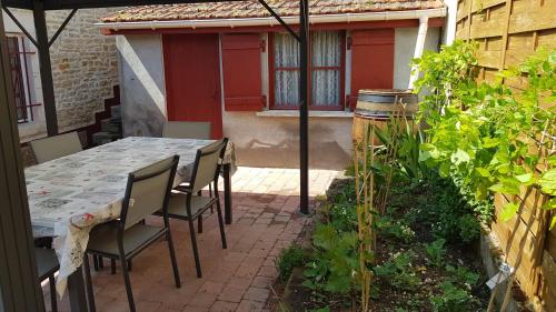 une table et des chaises assises sur une terrasse dans l'établissement Chez Laurence, à Santenay