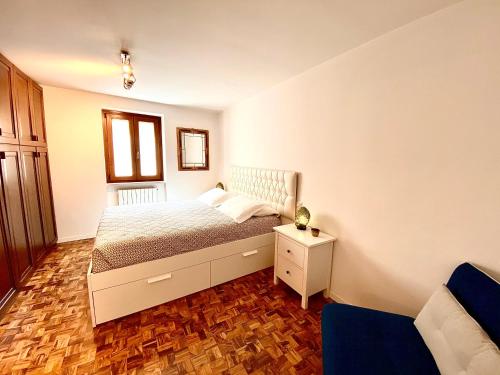 a small bedroom with a bed and a chair at Appartamento Alice in Bardolino