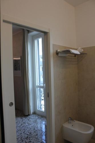 a bathroom with a toilet and a sink and a window at SoloSonno in Lecco