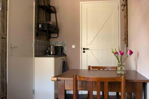 a kitchen with a table and a refrigerator at B&B De Hoffstal in Sassenheim