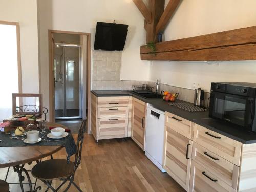 a kitchen with a table and a stove top oven at Le gîte des moineaux in Argeliers