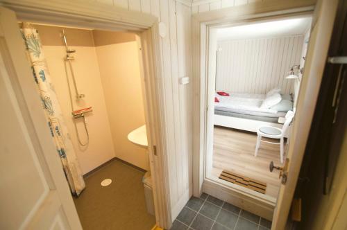 a small bathroom with a bedroom with a bed at Wikgården B&B in Gagnef
