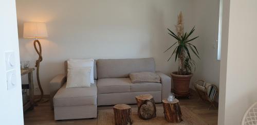 a living room with a couch and a potted plant at Opaline Baie de somme in Ault