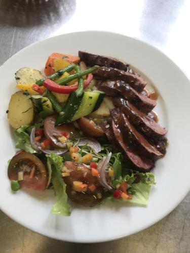 a white plate with a salad with sausage and vegetables at Maison d'hoursentut in Sainte-Marie-de-Campan