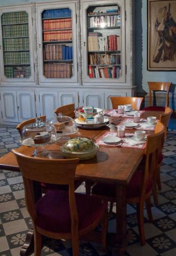 a wooden table with chairs and plates of food on it at B&B Canto Alla Porta Vecchia in Pistoia
