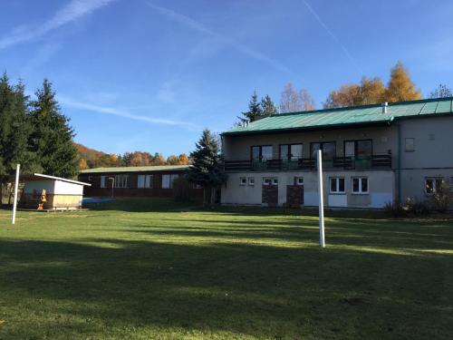 a large white building with a green roof at Penzion na Slunci in Staré Splavy