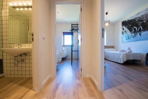 a bathroom with a sink and two beds in a room at CicloLodge in Lozoya